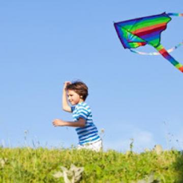 Child flying a kite on a sunny day